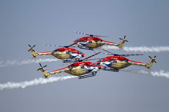 Indian Air Force helicopters cross paths while performing an aerobatic flight on the last day of the Aero India 2013 at Yelahanka air base in Bangalore.