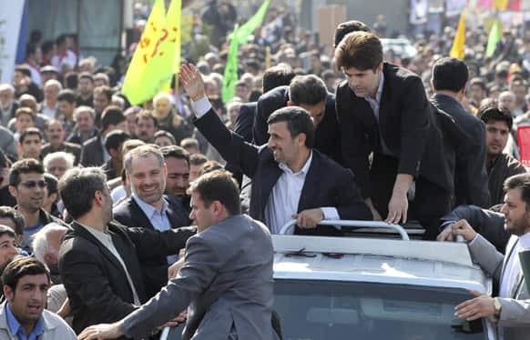 Iranian President Mahmoud Ahmadinejad, center, waves to well wishers from his car, during an annual rally commemorating the anniversary of the 1979 Islamic revolution, which toppled the late pro-U.S. Shah, Mohammad Reza Pahlavi, in Tehran.
