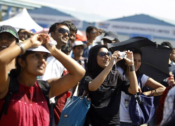 Visitors react as Russian air force air demonstration team, Russian Knights performing on the last day of the Aero India 2013 at Yelahanka air base in Bangalore.