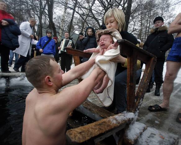 Aleksander and Anna prepare to bathe their two month old son Viktor during an ice swimmer`s festivity in St.Petersburg, Russia.