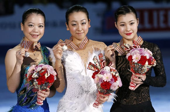Winner Mao Asada, center, second-placed, Akiko Suzuki, left, and third-placed Kanako Murakami, all of Japan, pose for photographers after the awarding ceremony of women`s events of the ISU Four Continents Figure Skating Championships in Osaka, Japan.