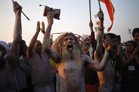 A Naga sadhu beats a small drum after bathing at Sangam, the confluence of Hindu holy rivers Ganges, Yamuna and the mythical Saraswati, during the Maha Kumbh festival at Allahabad.