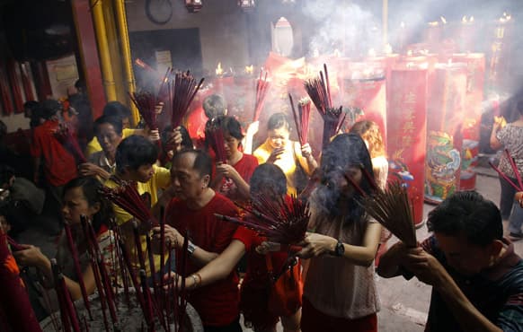 Indonesian ethnic Chinese hold incense sticks while praying during Lunar New Year celebrations at a temple in Jakarta.