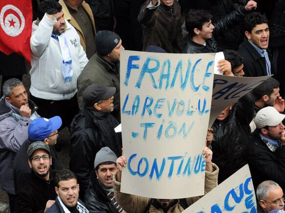A protestor holds up a banner reading