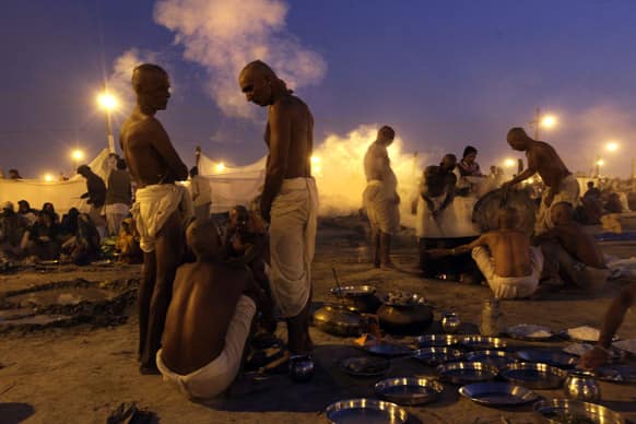 Devotees prepare food as they wait for day break to take a holy dip at Sangam, the confluence of the Rivers Ganges, Yamuna and mythical Saraswati, for Maha Kumbh festival, in Allahabad.