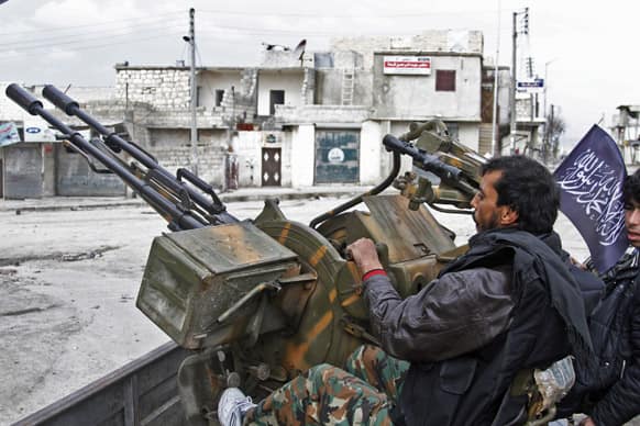Free Syrian Army fighters sit behind their antiaircraft machine gun in Aleppo, Syria. Syrian rebels brought their fight within a mile of the heart of Damascus on Friday, seizing army checkpoints and cutting a key highway.
