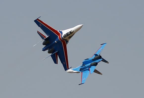 Russian air force aero demonstration team`s Sukhoi Su-27 fighters of the Russian Knights perform on the fourth day of the Aero India 2013 at Yelahanka air base in Bangalore.