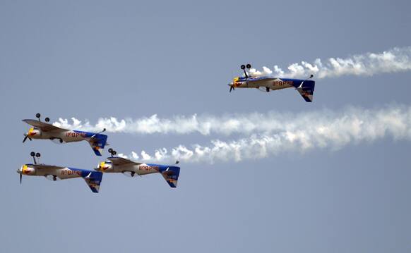 Flying Bulls Zlin 50LX single-engine and single-seater aerobatic display team from the Czech Republic perform inverted flight on the fourth day of the Aero India 2013 at Yelahanka air base in Bangalore.