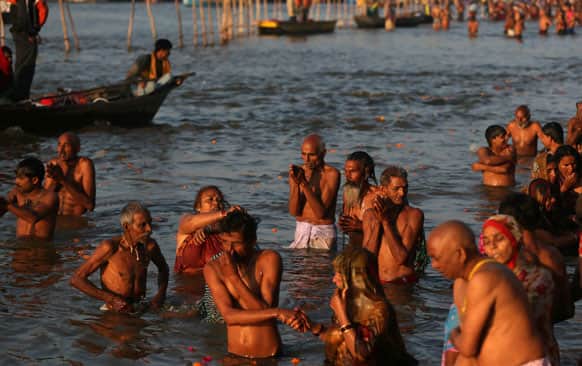 Devotees pray and take a holy dip at Sangam, the confluence of the Rivers Ganges, Yamuna and mythical Saraswati, during Maha Kumbh festival, in Allahabad.