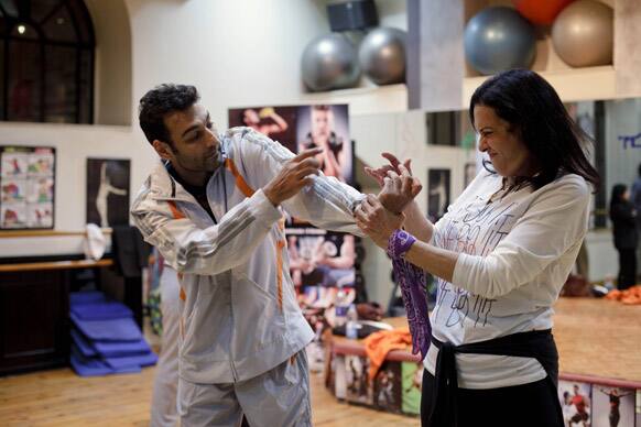 An Egyptian woman tries a self-defense move on instructor Ramy Jerair Latchinian at a workshop for women organized by Tahrir Bodyguard in response to a recent spate in sexual violence against female protesters in Cairo.