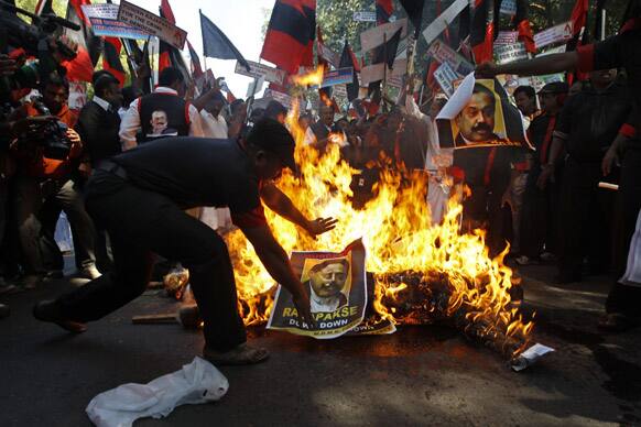 A Tamil activist belonging to MDMK burns an effigy and a portrait of Sri Lankan President Mahinda Rajapaksa during a protest in New Delhi.