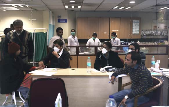 A doctor, wearing a mask as a precaution measures against swine flu virus, attends a patient at an emergency ward at a local hospital in New Delhi.