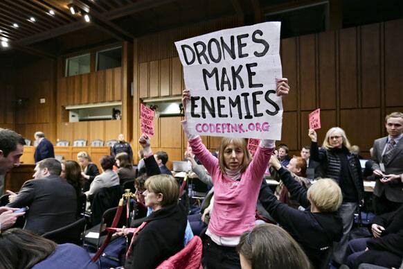 Protesters from CODEPINK, a group opposed to U.S. militarism, including co-founder Medea Benjamin, center, disrupt the start of the Senate Intelligence Committee confirmation hearing for John Brennan, on Capitol Hill in Washington.