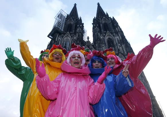 Carnival revellers stand in front of the Cologne cathedral while they celebrate the start of the street-carnival with its tradition of fools entering the town halls and women cutting off men`s ties with scissors on carnival`s so called