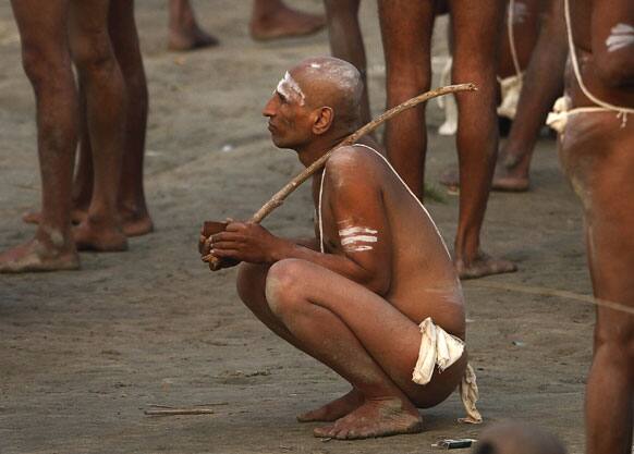 A Hindu holy men of the Juna Akhara sect listens to their spiritual leader after rituals that are believed to rid them of all ties in this life and dedicate themselves to serving God as a