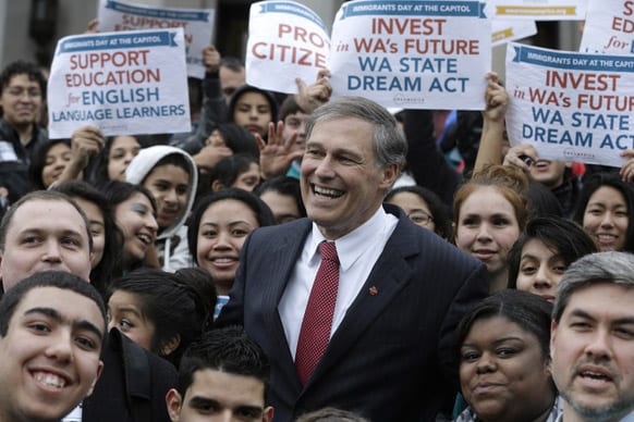 Washington Gov. Jay Inslee, center, poses for a group photo with with participants at a rally organized by the group OneAmerica supporting immigration rights, education, and other issues, at at the Capitol in Olympia, Wash.