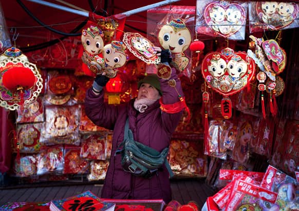 A vendor arranges decorations for Chinese New Year on display for sale at her store in Beijing. Chinese will celebrate the Lunar New Year on Feb. 10 this year which marks the Year of Snake.
