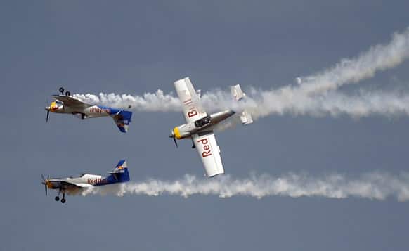 Red Bull`s Zlin 50LX single-engine single-seater aircrafts perform aerobatic flight during rehearsals on the eve of the Aero India 2013 at Yelahanka air base in Bangalore.
