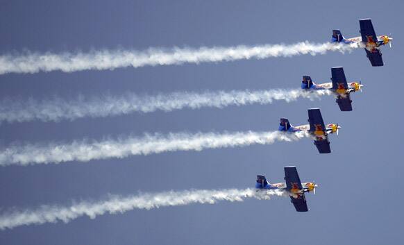 Red Bull `s Zlin 50LX single-engine and single-seater aircrafts perform during rehearsals on the eve of the Aero India 2013 at Yelahanka air base in Bangalore.
