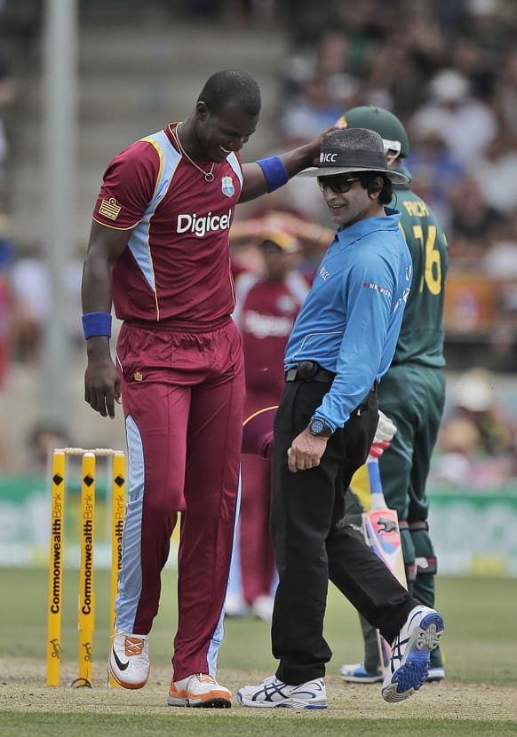 West Indies captain Darren Sammy, left, shares a light moment with umpire Asad Rauf during their One Day International Cricket match against Australia in Canberra.