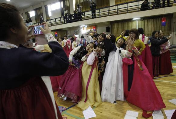 South Korean senior students clad in traditional costumes pose for a souvenir photo during a joint graduation and coming-of-age ceremony at Dongmyung Girls` High School in Seoul, South Korea.