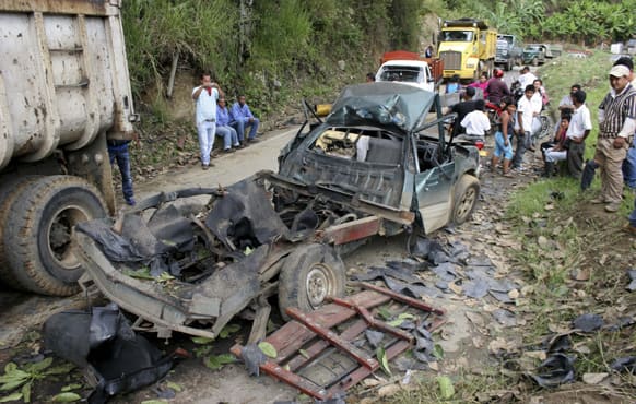 People look at a vehicle that exploded in El Palo, southern Colombia. Gen. Humberto Jerez, the local military commander, said that two car bombs were set off by rebels of the Revolutionary Armed Forces of Colombia, FARC, killing one man.