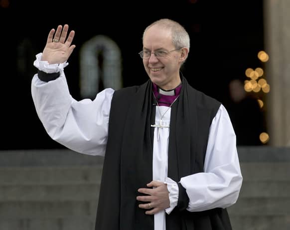 The new Archbishop of Canterbury, Justin Welby, waves outside St Paul`s Cathedral as he poses for the media following his ceremony known as the confIrmation of election in London.