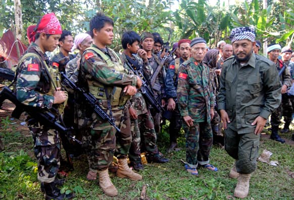 Rebel commander Khabir Malik, right, of the Moro National Liberation Front, which has an autonomy deal with the government, talks to his comrades at their camp in the volatile island of Jolo, Sulu province in southern Philippines.