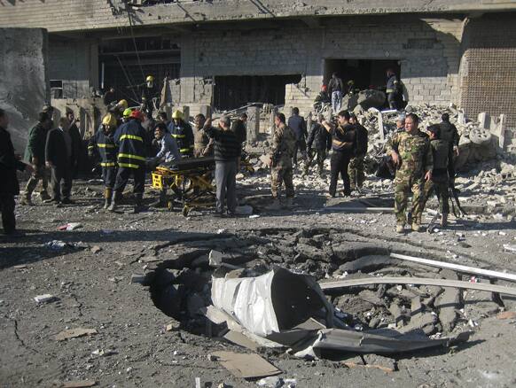 Iraqi civilians and security forces inspect a crater caused by a car bomb attack in Kirkuk, 180 miles (290 kilometers) north of Baghdad, Iraq.