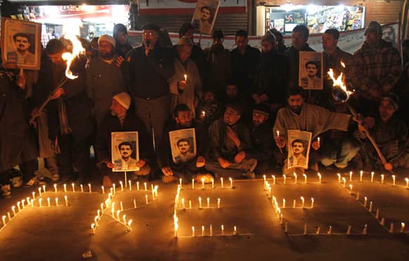 Activists and supporters of Jammu and Kashmir Liberation Front (JKLF) sit near candles during a protest in Srinagar.