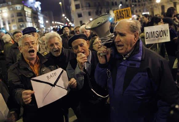 Protestors shouts slogans as they hold an envelope during a demonstration against corruption, in Madrid, Spain.
