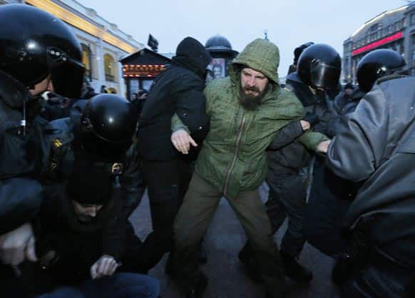 Police officers detain opposition activists during a banned anti-Kremlin protest in St.Petersburg, Russia.