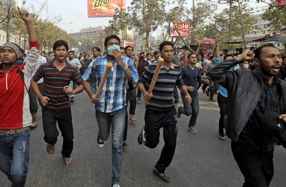 Jamaat-e-Islami activists armed with sticks march on a street in Dhaka. Hundreds of supporters of Bangladesh`s main Islamist party attacked police Monday in a busy commercial district in the nation`s capital, injuring many including at least eight security officers, an official said.