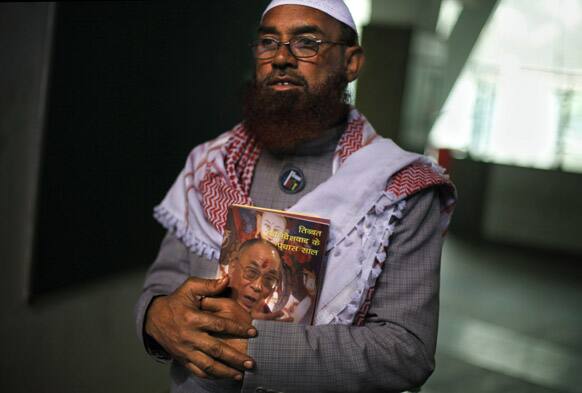 An Indian Muslim man holds a book with a portrait of Tibetan spiritual leader the Dalai Lama as he attends the Tibetan People`s Solidarity Campaign in New Delhi.