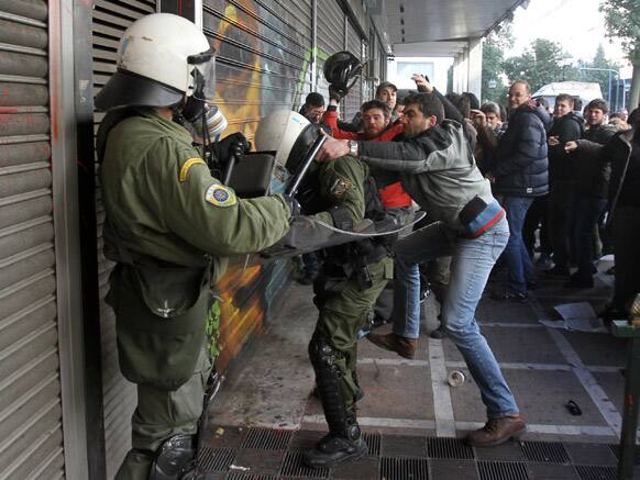 Protesters clash with riot police outside the Labor Ministry in Athens. Protesters from a Communist-back labor union forced their way into a government building and clashed with police who used tear gas to expel them.