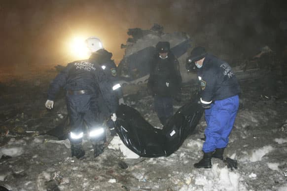 Emergency personnel work at the site of the plane crash outside Almaty. Kazakhstan. A passenger jet carrying at least 20 people crashed Tuesday in heavy fog near Kazakhstan`s principal city, Almaty, killing all on board, the airline and officials said.