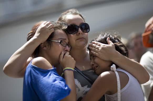 Girls cry in front of a makeshift memorial outside the Kiss nightclub where a fire killed over 230 people in Santa Maria, Brazil.