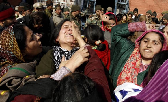A worker of anganwadi, or government sponsored child and mother care, cries as others shout slogans during a protest in Srinagar.