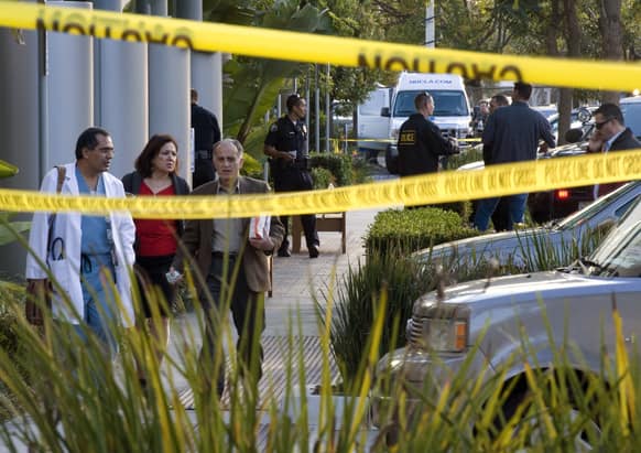 Police investigate as medical personnel exit the scene outside a medical office near Hoag Hospital where shots were fired in Newport Beach, Calif. Police say a doctor has been shot and killed and a man is in police custody.