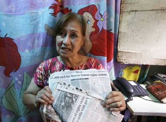 Carmencita Florentino, 64, holds newspaper clippings during an interview in her home at a poor neighborhood of Tatalon, Quezon city, northeast of Manila, Philippines.