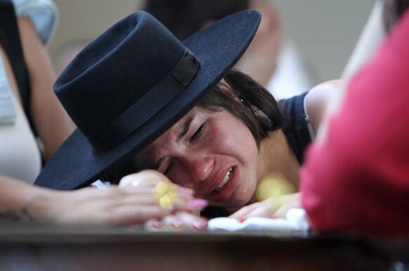 A woman cries over the coffin of her boyfriend at a gymnasium where bodies were brought for identification in Santa Maria city, Rio Grande do Sul state, Brazil.