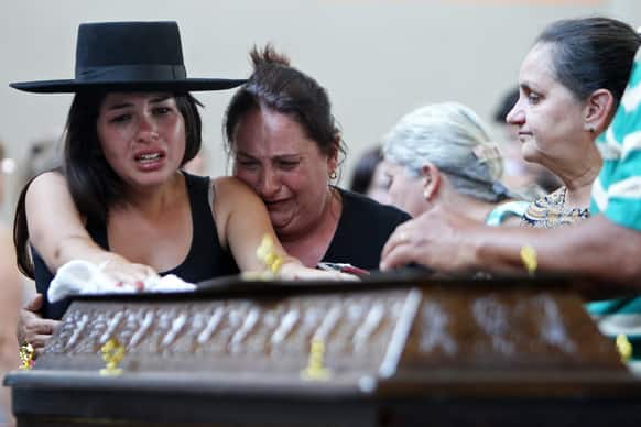 Relatives cry next to a coffin at a gymnasium where bodies were brought for identification in Santa Maria city, Rio Grande do Sul state, Brazil.