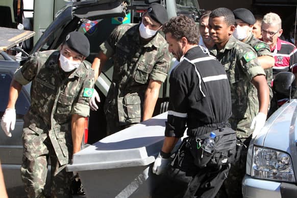 Brazil`s soldiers carry a container with the remains of a victim outside a gymnasium where bodies were brought for identification in Santa Maria city, Rio Grande do Sul state, Brazil.