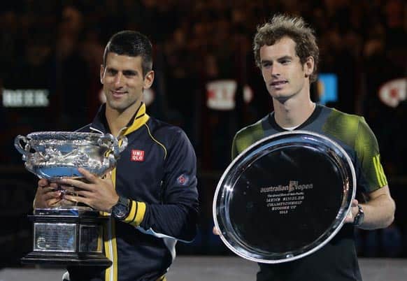 Serbia`s Novak Djokovic, left,holds his trophy after defeating Britain`s Andy Murray, right, in the men`s final at the Australian Open tennis championship in Melbourne.