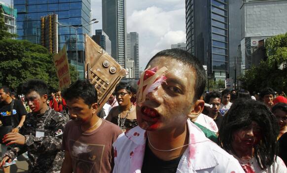 Participants dressed as zombies perform during the annual Zombie Walk in Jakarta. Hundreds of participants marched in the capital to collect donations for recent flood victims and campaign against the disposal of waste to public places.