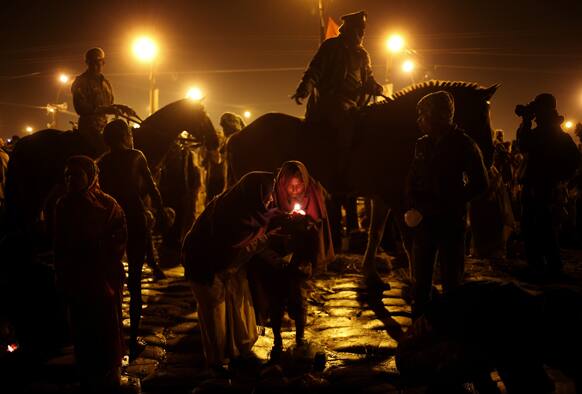 Policemen patrol an area as hindu devotees light a lamp to perform rituals at