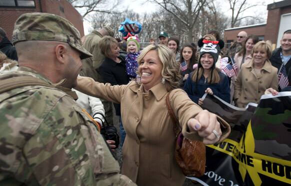 Amy DeRosia greets her husband, Sgt. Chad DeRosia, as members of the 303rd Military Police Company return home at the U.S. Army Reserve Center in Jackson, Mich.