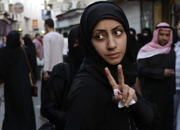 A Bahraini anti-government protester gestures after being injured in the shoulder by a stun grenade thrown by riot police in Manama, Bahrain.