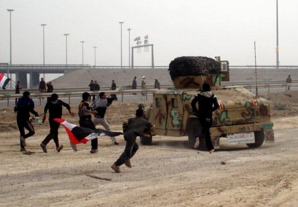Protesters throw stones towards Iraqi soldiers at a checkpoint during clashes in Fallujah, 40 miles (65 kilometers) west of Baghdad.
