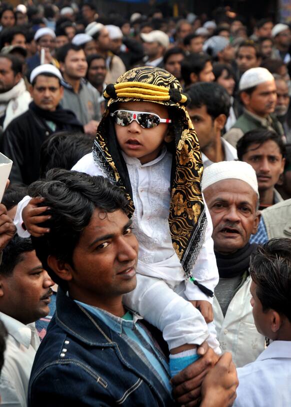 An Indian Muslim carries a child on his shoulder and participates in a procession to mark the birth anniversary of Prophet Muhammed in Lucknow.
